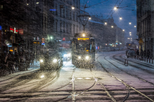 A tram and cars are seen cover in snow during a snowfall  in Krakow.